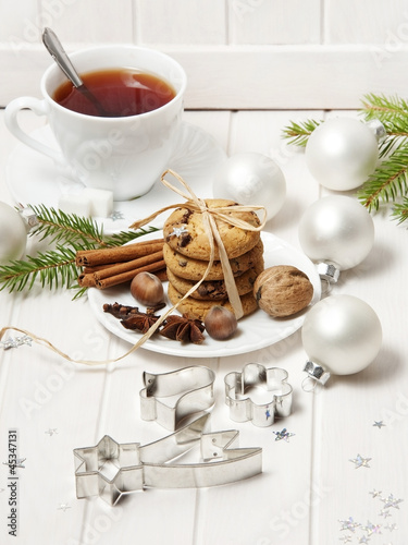 Photo: christmas biscuits and a cut of tea on white wooden background christmas biscuits and a cut of tea on white wooden background