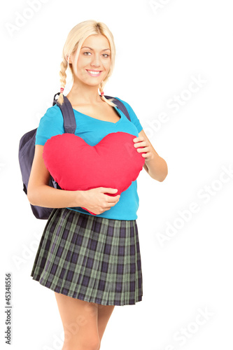 Photo: Blond beautiful student holding a heart shape object Blond beautiful student holding a heart shape object
