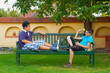 Two teenage boys sitting on the bench and playing with the ball