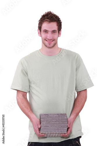 Photo: Man carrying pile of tiles Man carrying pile of tiles