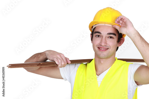 Photo: Construction worker carrying plywood Construction worker carrying plywood