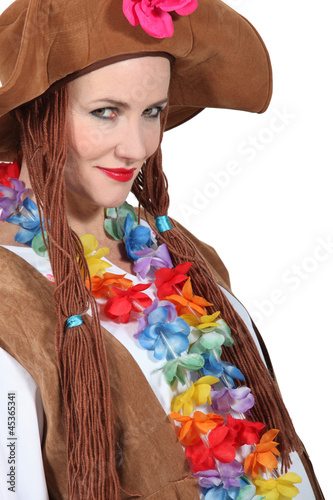 Photo: Woman wearing brown hat and wig with flowers around neck Woman wearing brown hat and wig with flowers around neck