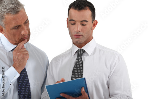 Photo: Two businessmen going over proposal Two businessmen going over proposal