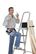 Carpenter posing by step-ladder