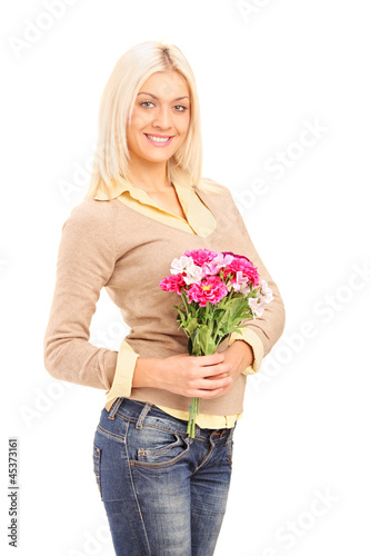 Photo: A smiling blond woman holding a bunch of flowers A smiling blond woman holding a bunch of flowers