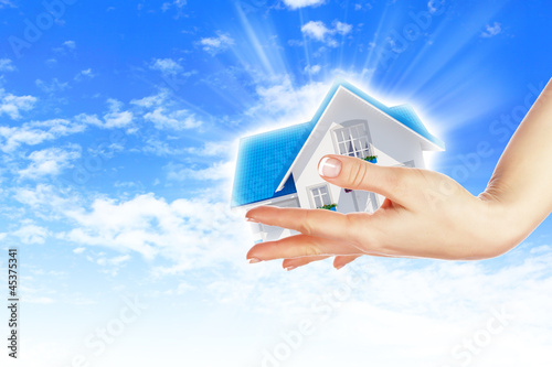 Illustration: the house in hands on blue sky the house in hands on blue sky