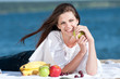 Woman on beach eating fruits