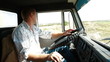 Lorry driver at the wheel of truck on country road