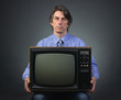 A man holding a retro television