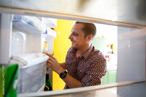 Photo: Happy men found favorite drink in the fridge Happy men found favorite drink in the fridge