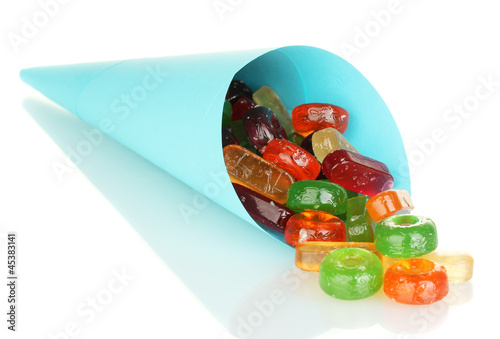 Photo: Tasty colorful candies in bright bag isolated on white Tasty colorful candies in bright bag isolated on white