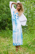 The beautiful woman in a blue dress in the field
