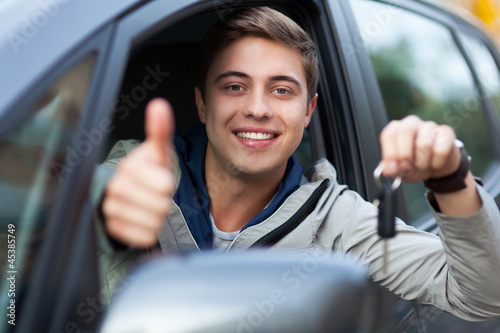 Photo: Young man sitting in car holding car keys Young man sitting in car holding car keys