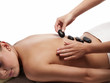 Pretty young woman gets hot stones on his back - isolated