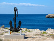 A big black anchor located on the coast