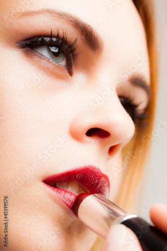 Photo: Woman applying lipstick Woman applying lipstick