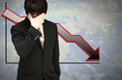 Stressed businessman with low financial graph