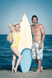 Couple at the beach with surfboard.