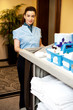 Charming female executive holding toiletries cart