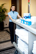 Beautiful employee psuhing housekeeping cart