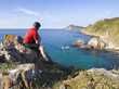Cyclist sitting, staring at a coastal landscape (2)