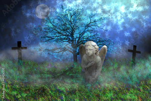 Photo: Angel with wings sitting on the mossy grass Angel with wings sitting on the mossy grass