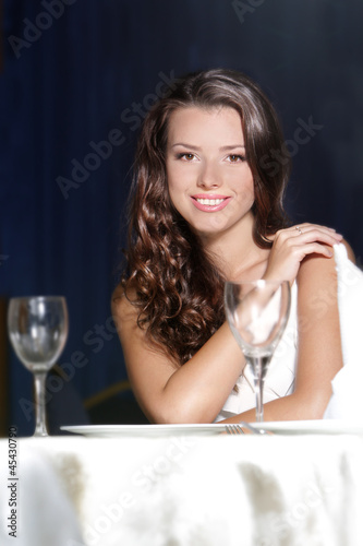 Photo: portrait of young happy beautiful woman in restaurant portrait of young happy beautiful woman in restaurant