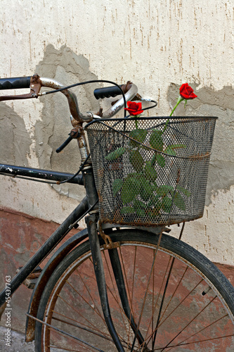 Photo: Red roses in basket of old rusty bicycle Red roses in basket of old rusty bicycle