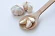 Garlic cloves in wooden cooking spoon isolated on white