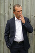 Smartly dressed man smoking a cigarette