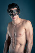 Portrait of young man shirtless with carnival mask 