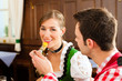 Paar in Bayerischer Tracht isst in Wirtschaft oder Restaurant