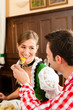 Paar in Bayerischer Tracht isst in Wirtschaft oder Restaurant