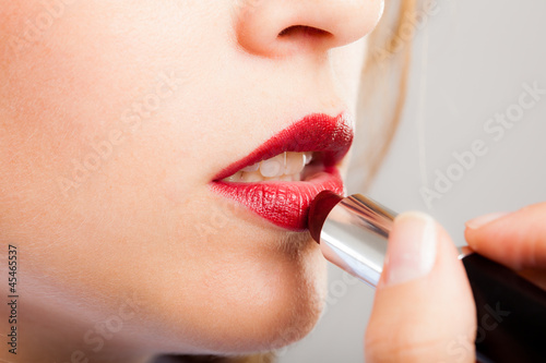 Photo: Woman applying lipstick Woman applying lipstick