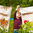 Sweet  five-year girl with clothespin and the clothesline
