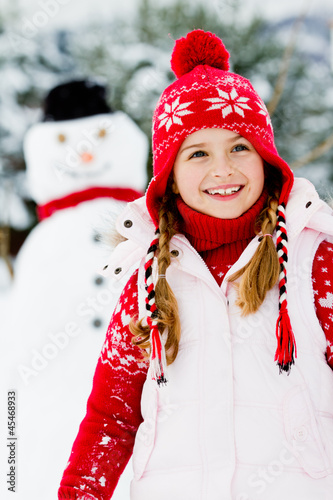 Photo: Winter fun, snowman and happy child Winter fun, snowman and happy child