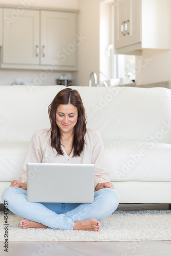 Photo: Woman happily using laptop Woman happily using laptop