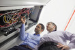 Technicians checking wires of server
