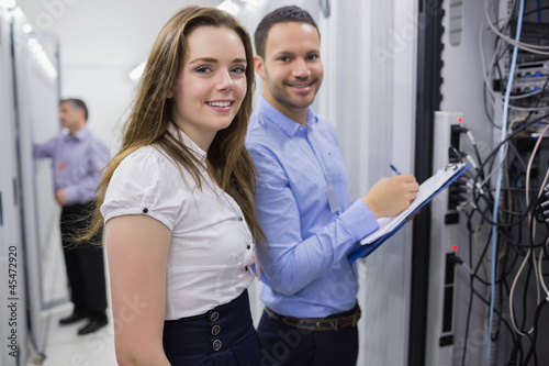 Photo: Two smiling technicians checking the servers Two smiling technicians checking the servers