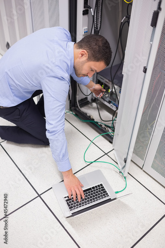 Photo: Technician connecting his laptop to server Technician connecting his laptop to server