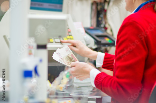 Photo: Cash-desk with cashier and terminal in supermarket. Serve custom Cash-desk with cashier and terminal in supermarket. Serve custom