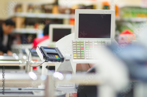Photo: Multiple cash-desks with cashier and terminal in supermarket Multiple cash-desks with cashier and terminal in supermarket