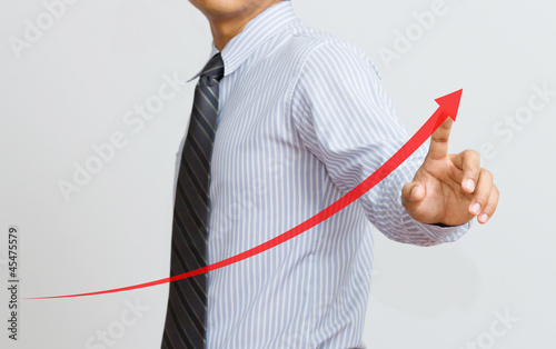 Photo: a Business hand pressing a growth chart a Business hand pressing a growth chart
