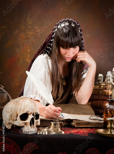 Photo: Witch writing in the book of shadows Witch writing in the book of shadows