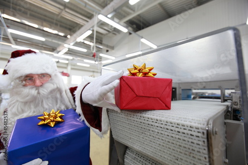 Photo: Santa claus receiving gifts from presents machine Santa claus receiving gifts from presents machine