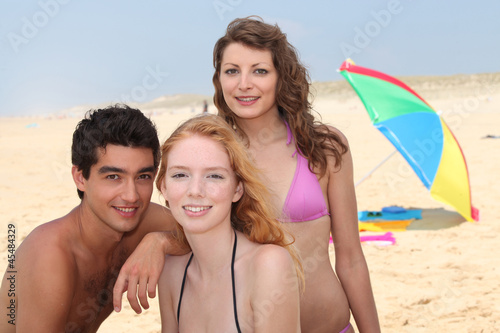 Photo: three friends having fun on the beach three friends having fun on the beach
