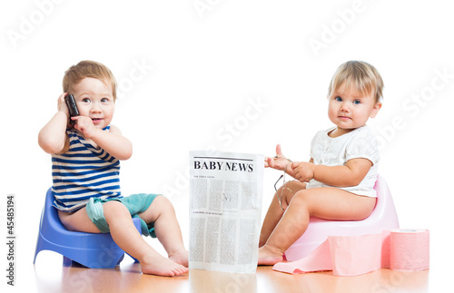 Photo: funny children with newspaper and pda on chamberpot funny children with newspaper and pda on chamberpot