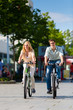 Photo: Paar in Stadt fährt mit Fahrrad in Freizeit Paar in Stadt fährt mit Fahrrad in Freizeit