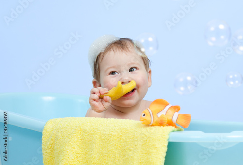 Photo: adorable baby taking bath in blue tub adorable baby taking bath in blue tub