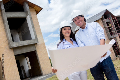 Photo: Couple holding blueprints Couple holding blueprints